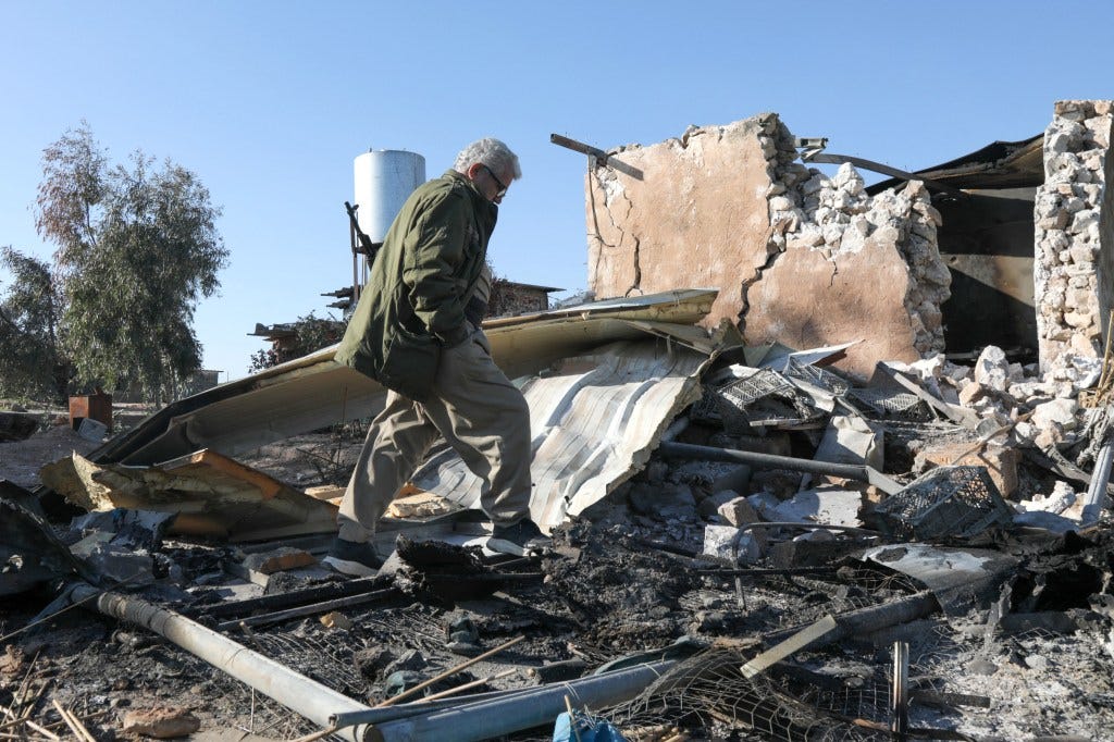 A man walking through the rubble of a destroyed building at the Azadi Camp in northern Iraq.