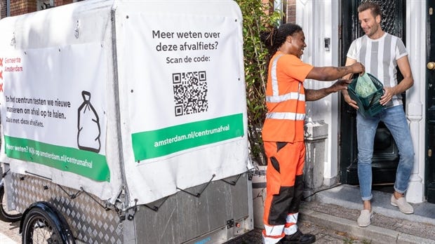 Medewerker neemt afval aan van bewoner Medewerker neemt afval aan van bewoner