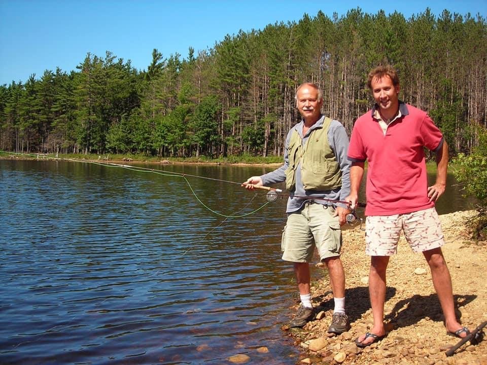 A couple of men fishing on a lake

Description automatically generated