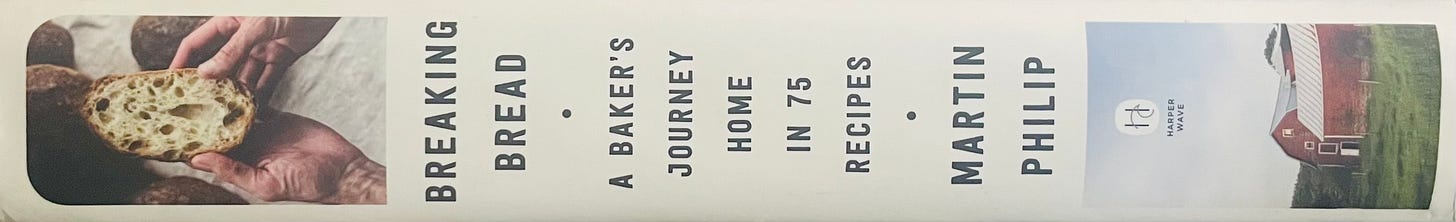 Book spine of Breaking Bread by Martin Philip. White cover with two photos, one of a barn in a field and the other of a slice of sourdough bread.