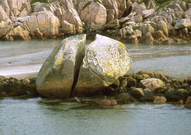 A large rock in the water

Description automatically generated