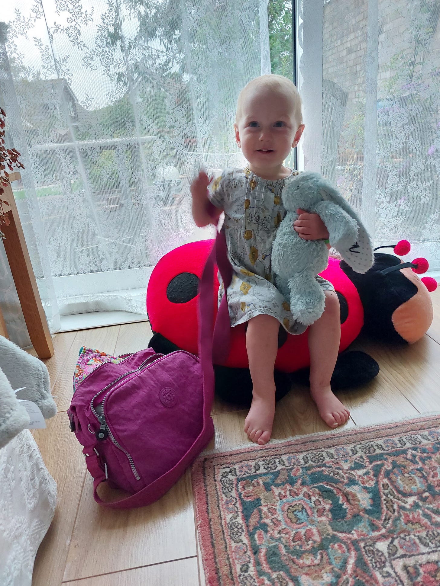 Smiling toddler sitting in a large fluffy ladybird