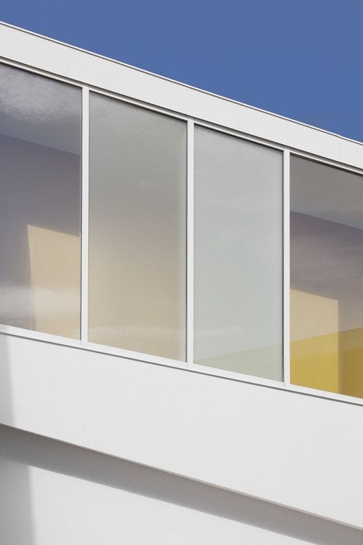 This may contain: the side of a white building with multiple windows