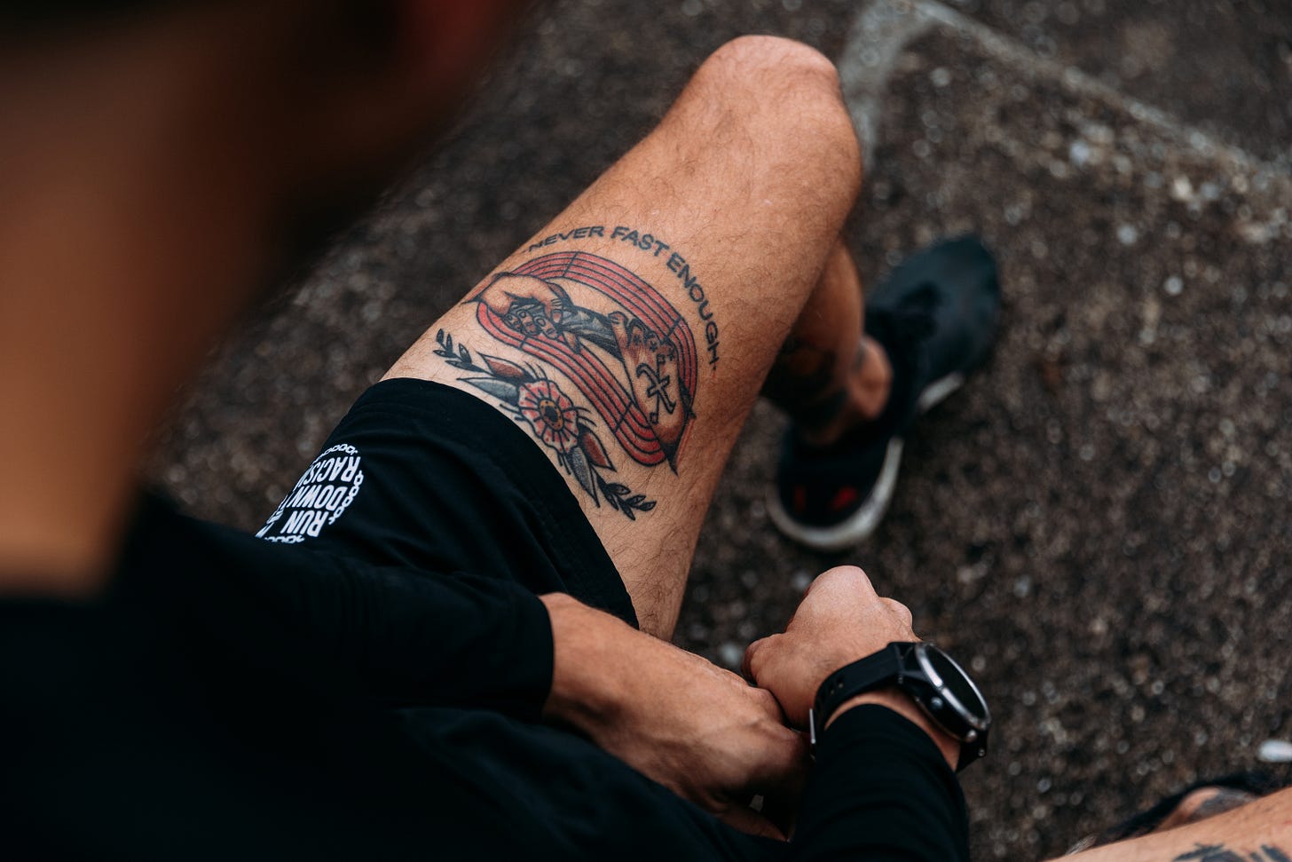 The author's tattooed leg showing the lettering "never fast enough"