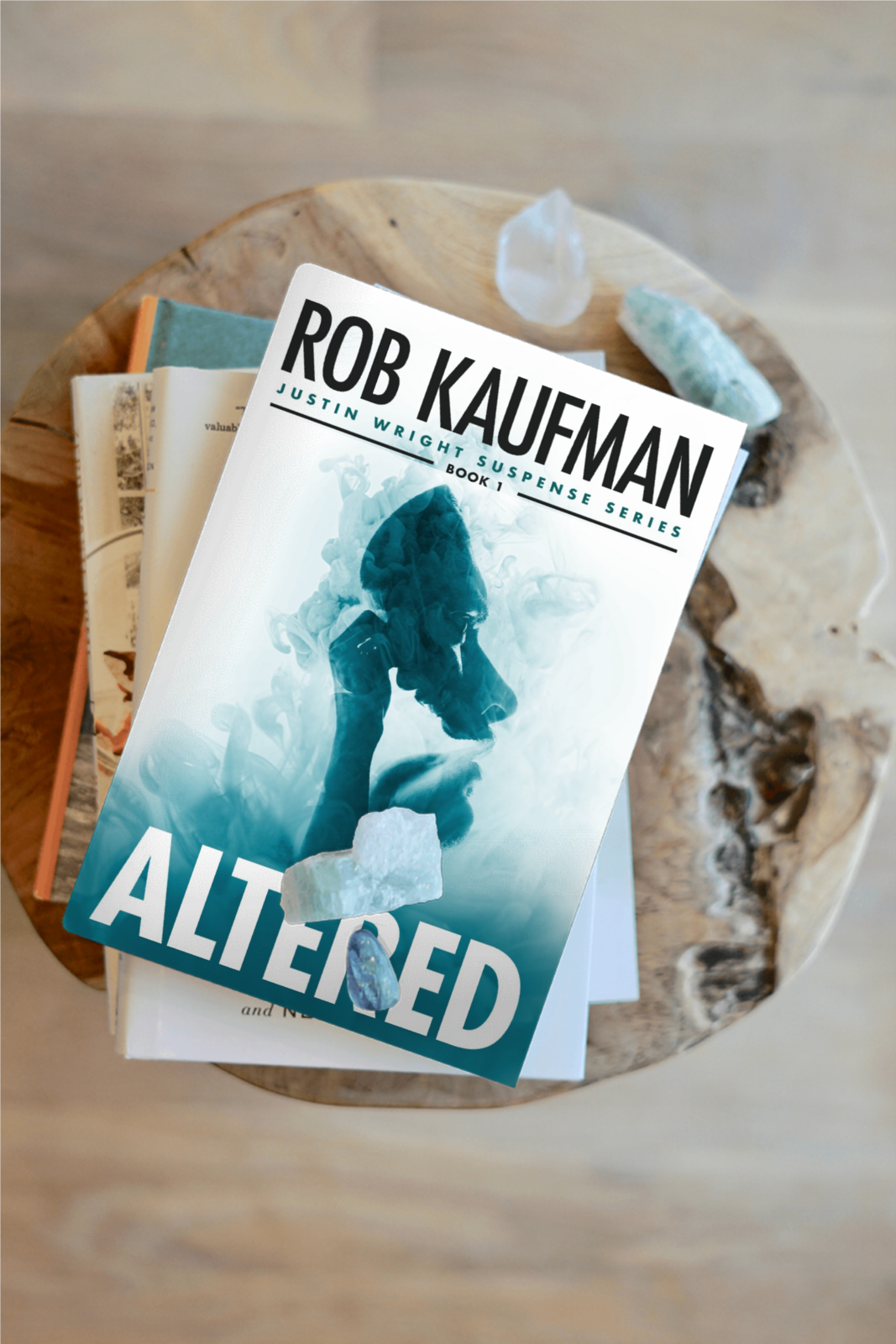 Book "Altered" by Rob Kaufman sitting on a wood end table on top of other books. Book "Altered" by Rob Kaufman sitting on a wood end table on top of other books.