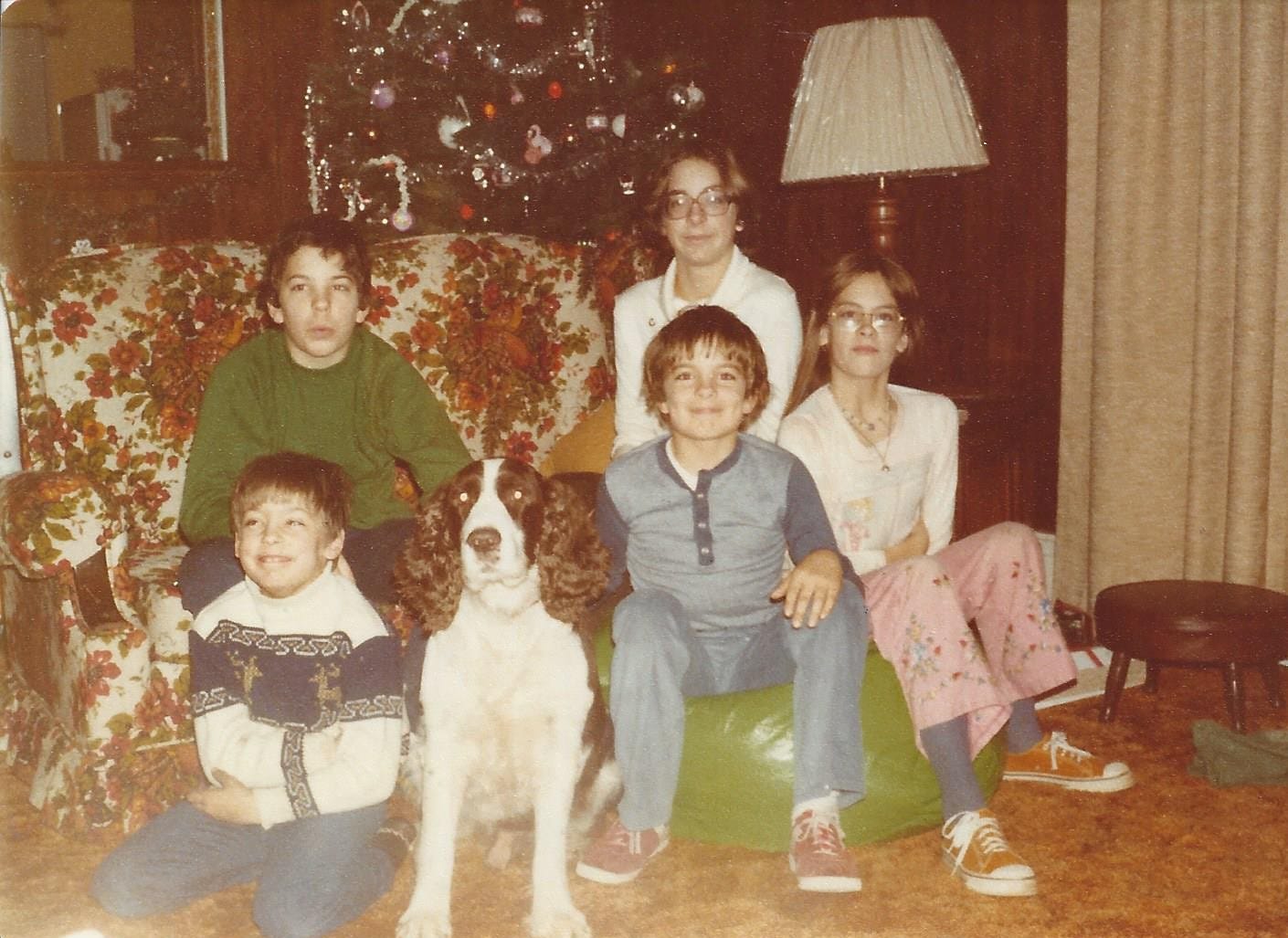 Five teen and pre-teen cousins--two girls and three boys--posed in front of a Christmas tree