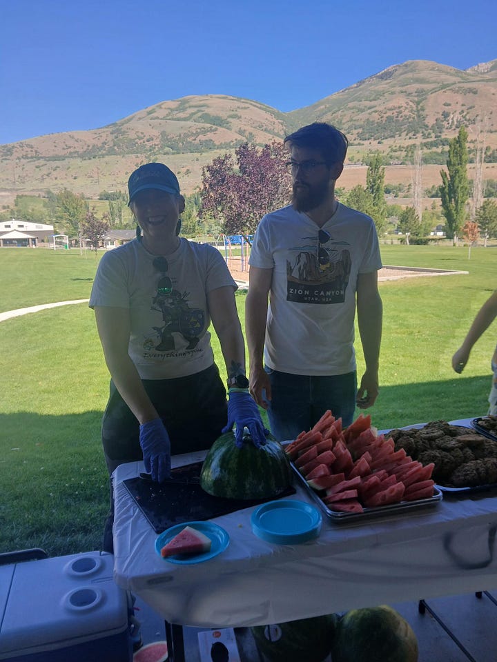 1. a man playing a guitar and singing with a woman. 2. two people standing behind a refreshments table loaded with watermelon and cookies.