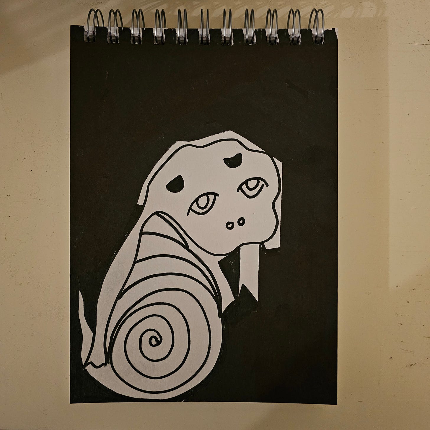 * A high-contrast black and white ink drawing featuring a stylized creature that hybrids a puppy's head with a coiled, snake-like or snail-like body. The figure is rendered in white against a heavy black ink background. The creature has large, innocent eyes but a spiral body, suggesting transformation or constriction. * A high-contrast black and white ink drawing featuring a stylized creature that hybrids a puppy's head with a coiled, snake-like or snail-like body. The figure is rendered in white against a heavy black ink background. The creature has large, innocent eyes but a spiral body, suggesting transformation or constriction.