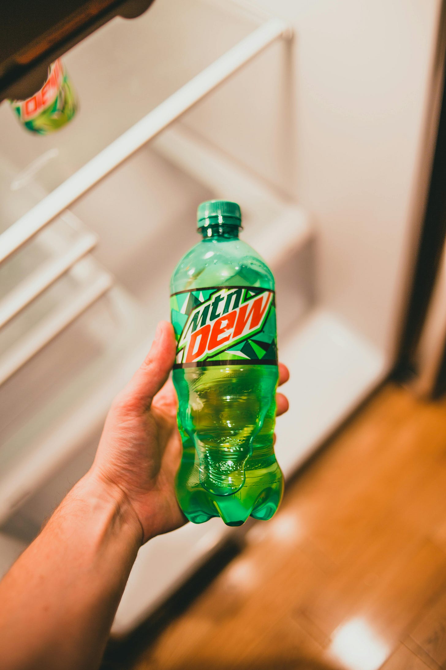 A Person Holding a Bottle of Mountain Dew · Free Stock Photo