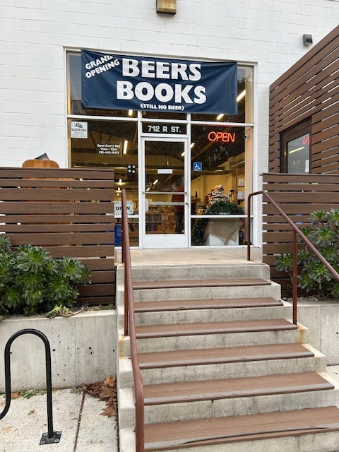 Steps lead up to the front door of Beers Books. A sign says Beers Books Grand Opening Still no beer.