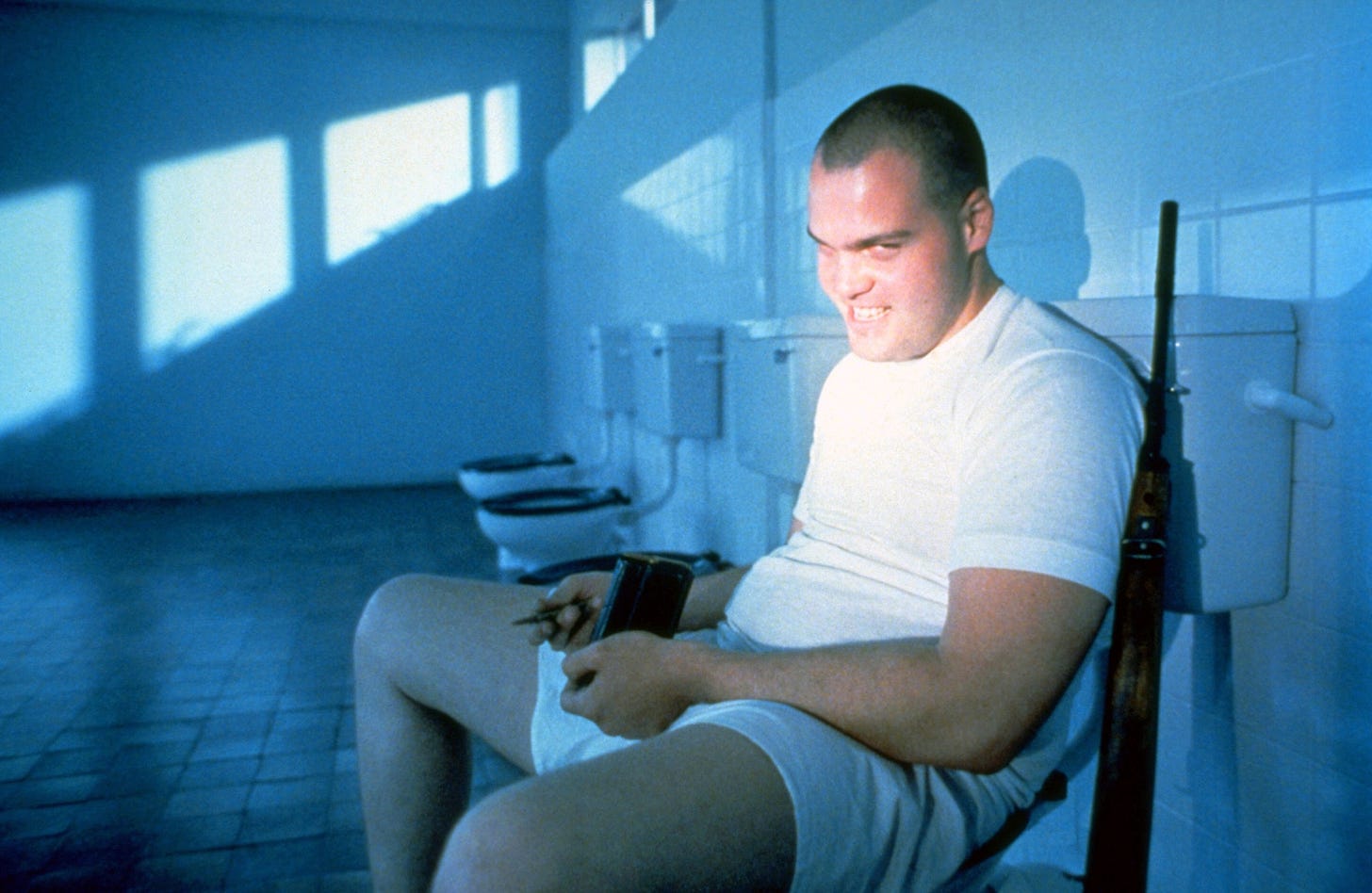 Gomer Pyle sits leg spread grinning evilly in a communal blue lit bathroom Gomer Pyle sits leg spread grinning evilly in a communal blue lit bathroom