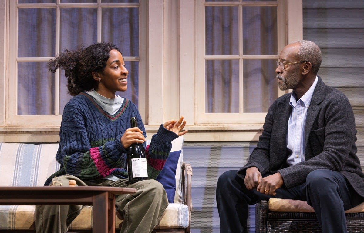 Ayo Edebiri holds a bottle of sparkling wine while smiling at a stern Don Cheadle Ayo Edebiri holds a bottle of sparkling wine while smiling at a stern Don Cheadle