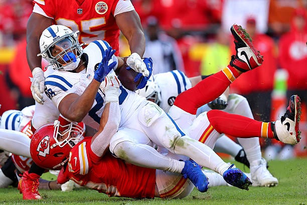 Jonathan Taylor of the Indianapolis Colts is tackled by Drue Tranquill of the Kansas City Chiefs in overtime of the game at Arrowhead Stadium on...