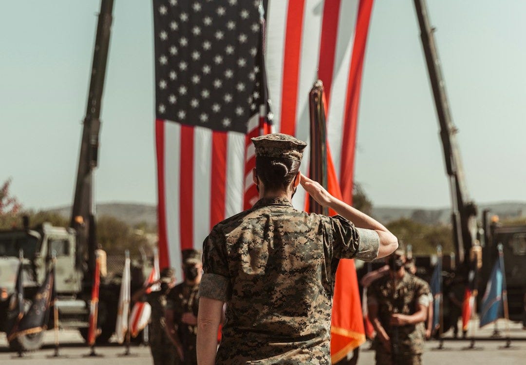 a group of people in military uniforms holding american flags