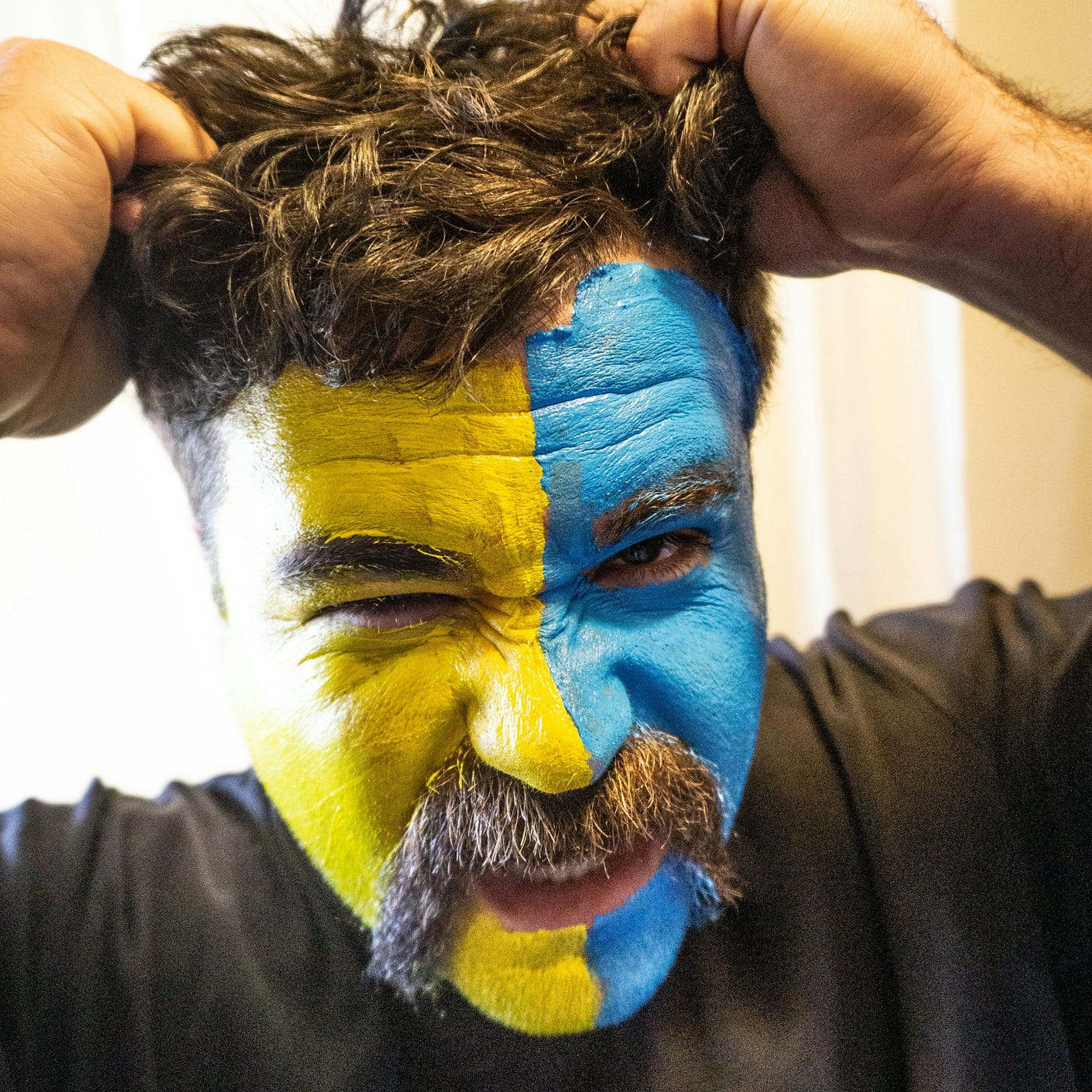 a man with his face painted in the colors of the swedish flag