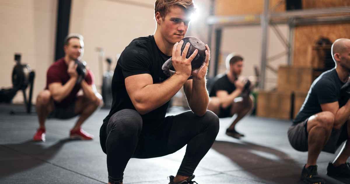 people doing goblet squats in a group class