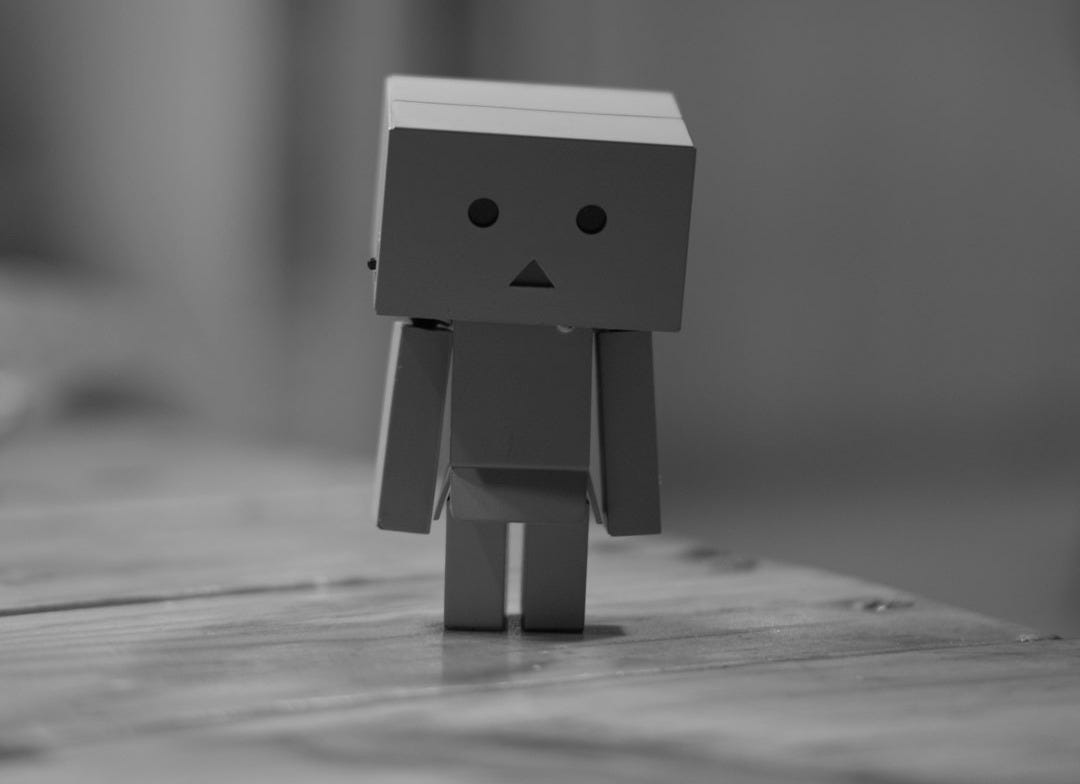 grayscale photo of box robot on table