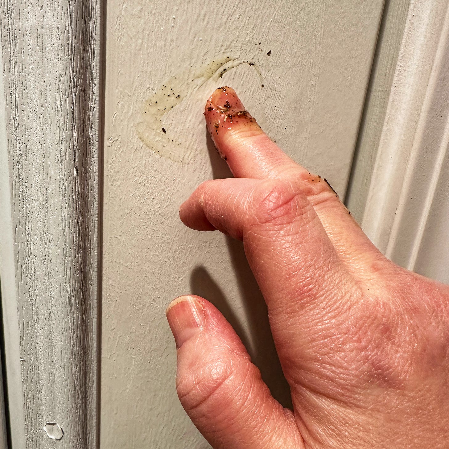 a finger draws an eye on a door with oil