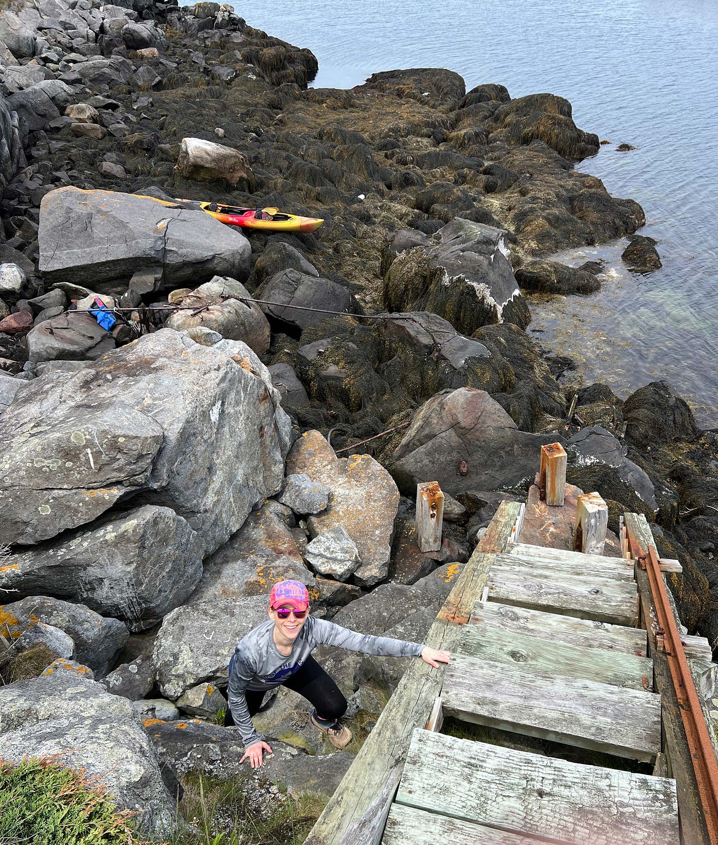 K. Woodman-Maynard, climbs up an abandoned wooden staircase on an abandoned island in Maine for her upcoming graphic novel.