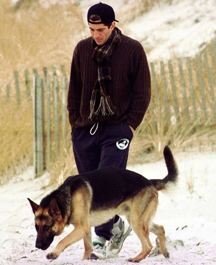This may contain: a man walking his dog in the snow