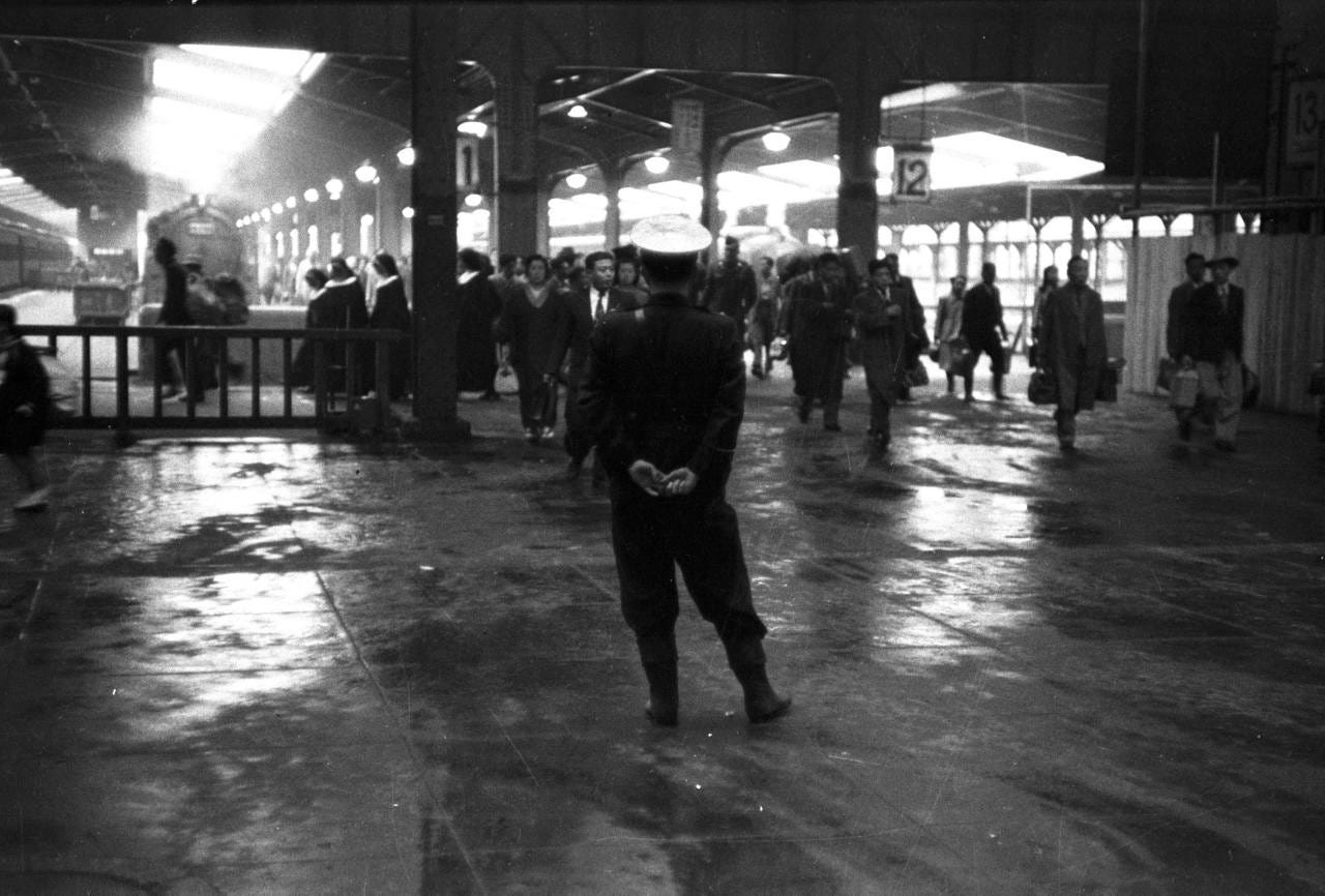 A police officer observing passengers at Ueno Station in Tokyo c. 1951. A police officer observing passengers at Ueno Station in Tokyo c. 1951.