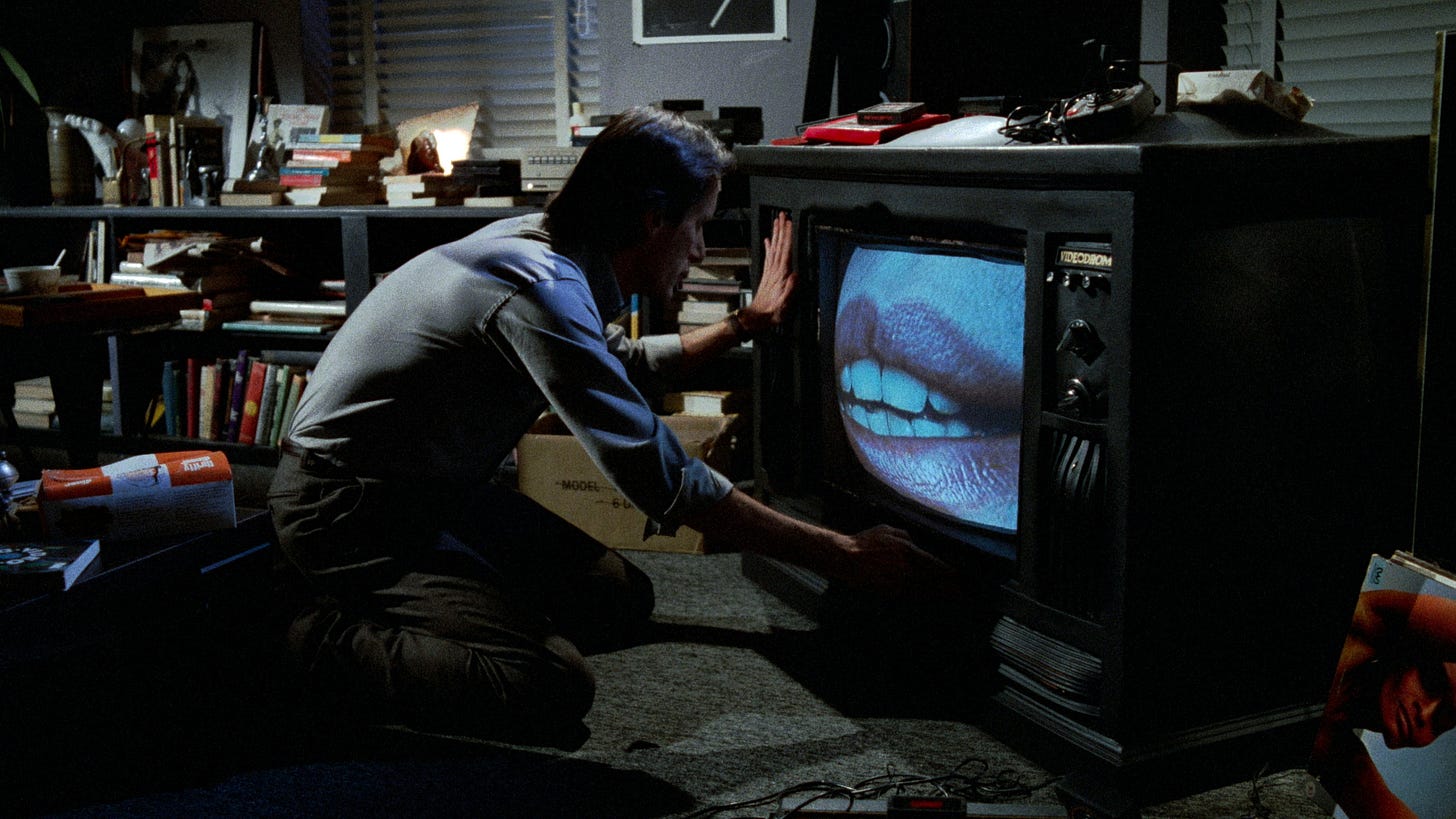 Videodrome | Still features James Woods as Max Renn observing a television with a big mouth on its display. Videodrome | Still features James Woods as Max Renn observing a television with a big mouth on its display.