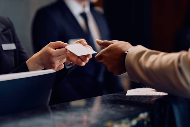 Close up of black man receiving room cardkey while checking in at the hotel. Close up of hotel receptionist giving room cardkey to African American hotel guest. hotel front desk stock pictures, royalty-free photos & images