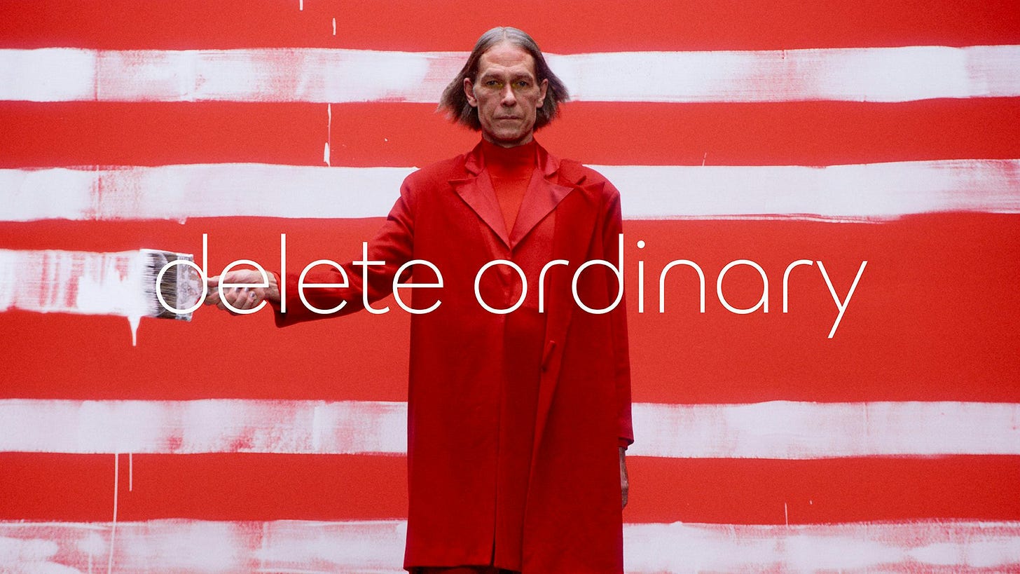 New Jaguar branding featuring the tagline 'delete ordinary' against a photo of a person wearing a red suit appearing to paint white stripes on the screen