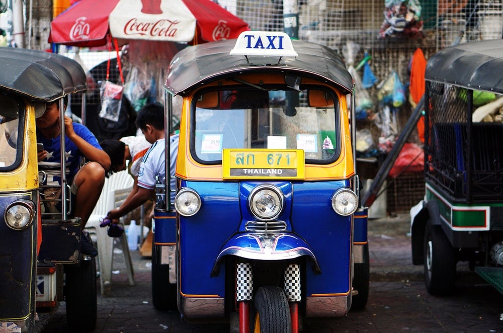 yellow and blue auto rickshaw parked beside auto rickshaw yellow and blue auto rickshaw parked beside auto rickshaw