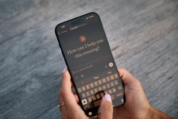 Two hands holding a smartphone with its screen opened to the Claude chatbot.