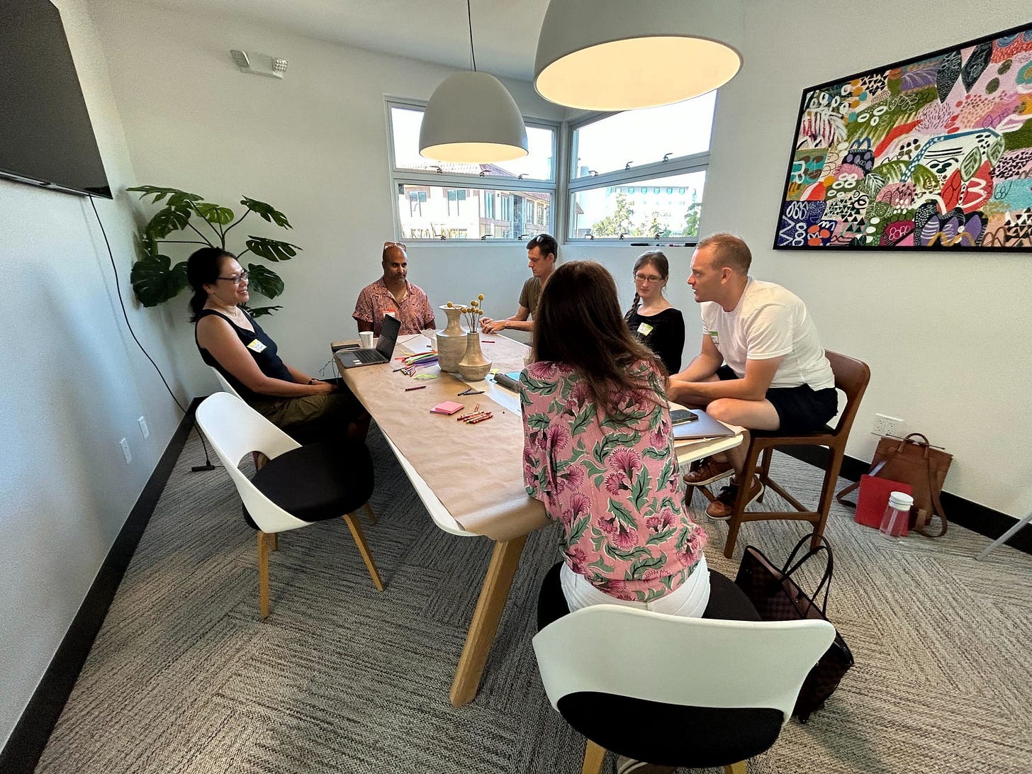 a small group of people talking around a rectangular table