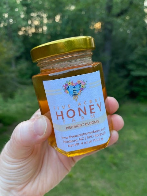 small jar of rose honey in a woodland area