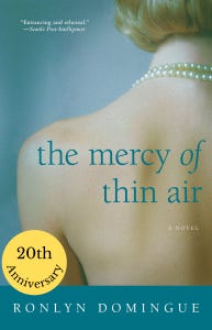 book cover for THE MERCY OF THIN AIR by Ronlyn Domingue  light blue background showing a naked white women's back she has a blond bob and is wearing a double strand of pearls around her neck