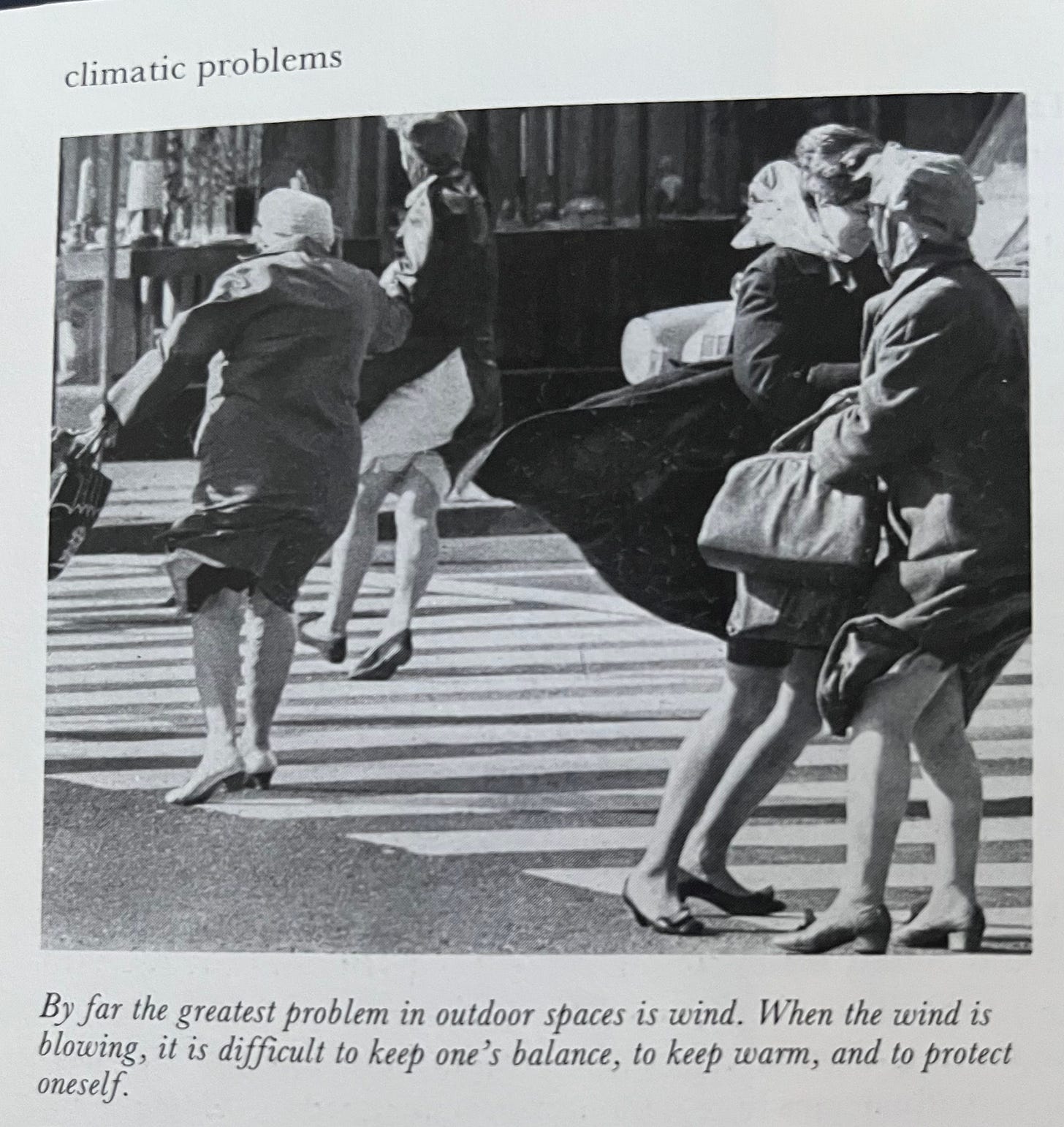 Black-and-white photograph of a street scene, with people struggling with the wind. The caption says "By far the greatest problem in outdoor spaces is wind. When the wind is blowing, it is difficult to keep one's balance, to keep warm, and to protect oneself." Black-and-white photograph of a street scene, with people struggling with the wind. The caption says "By far the greatest problem in outdoor spaces is wind. When the wind is blowing, it is difficult to keep one's balance, to keep warm, and to protect oneself."