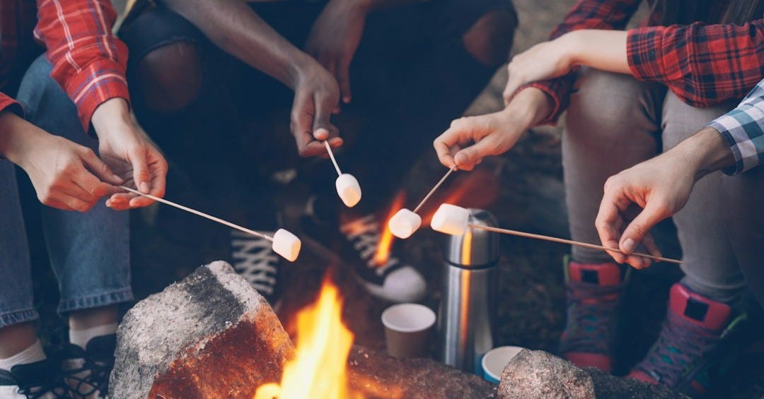 Friends roasting marshmallows over a campfire Friends roasting marshmallows over a campfire