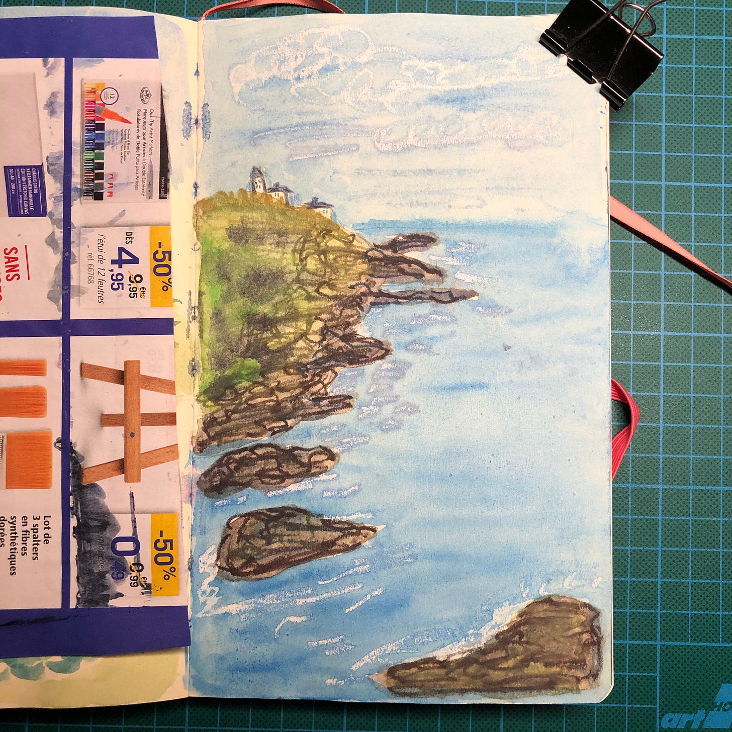 Photo d'une page de mon sketchbook où j'ai peint une falaise et la mer. Photo d'une page de mon sketchbook où j'ai peint une falaise et la mer.