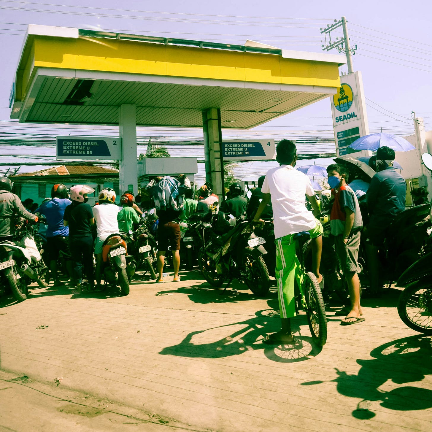 a group of people standing around a gas station