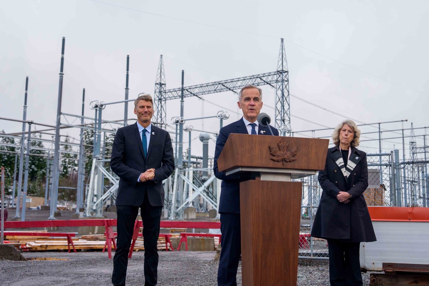 A person standing at a podium with a microphone

AI-generated content may be incorrect.