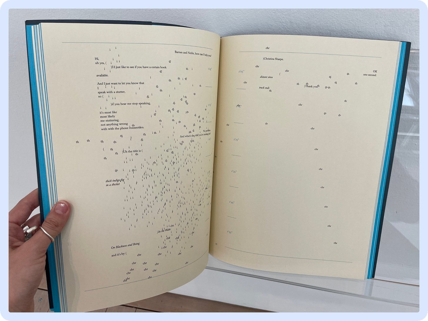 A photo of a two-page spread in a large format poetry book. The formatting is experimental, with lines, words and even letters spread across the page, almost as if they have been disrupted by a gust of wind. A photo of a two-page spread in a large format poetry book. The formatting is experimental, with lines, words and even letters spread across the page, almost as if they have been disrupted by a gust of wind.