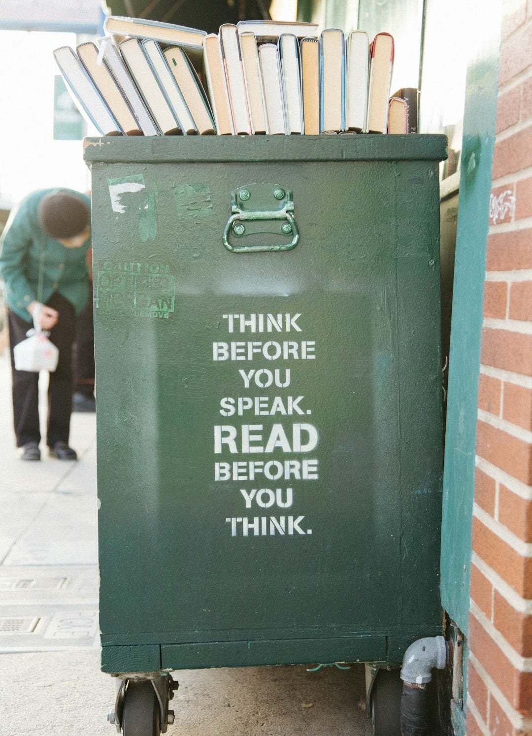 books over green trolley bin