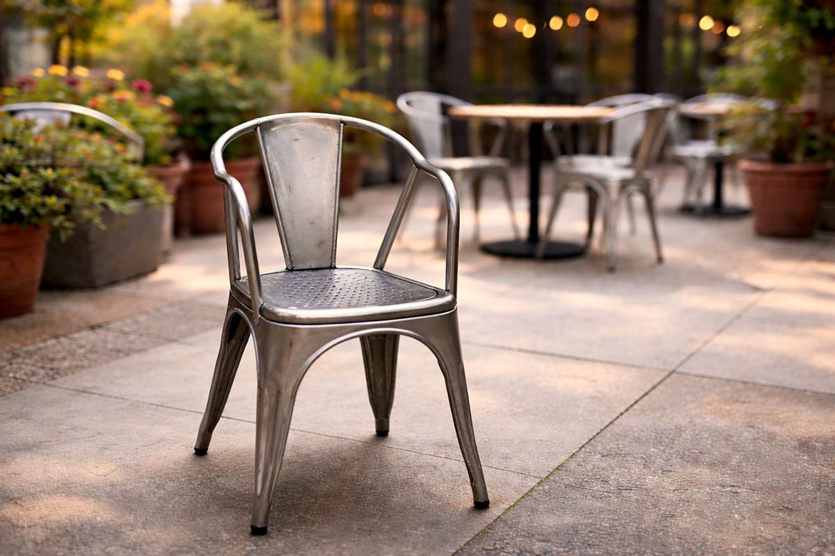 Metal outdoor café chair with a narrow seat that tightens at the back, creating a restrictive sitting space