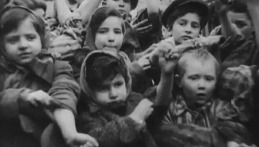 Holocaust survivor Tova Friedman stands on the left with her sleeve rolled up on Liberation Day.