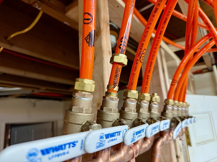 Two photos showing PEX connected to a distribution manifold.