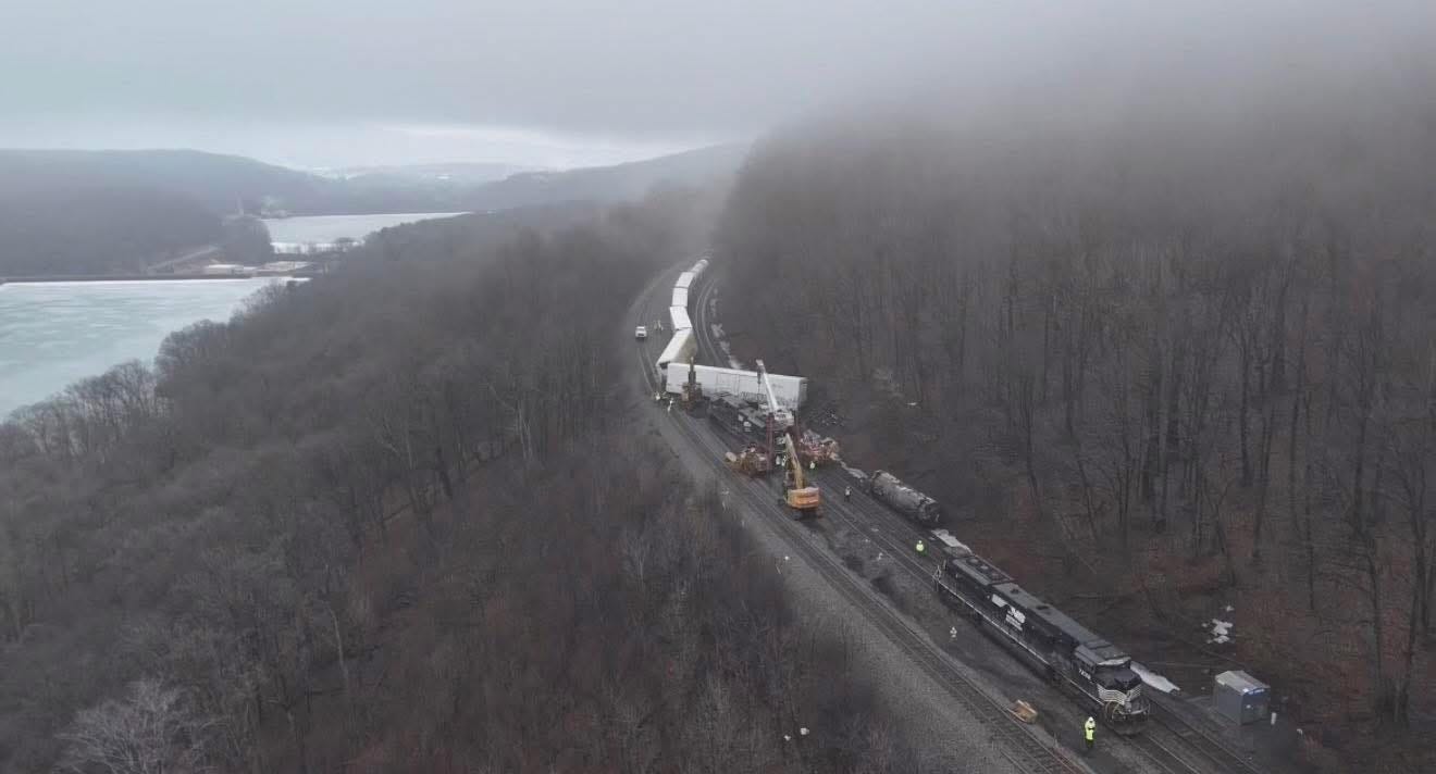 May be an image of train, road, railroad and fog