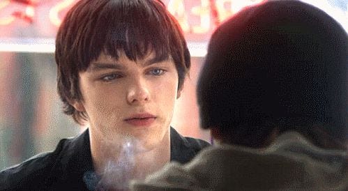 This may contain: the young man is talking to his friend in front of a neon sign that reads, don't stop