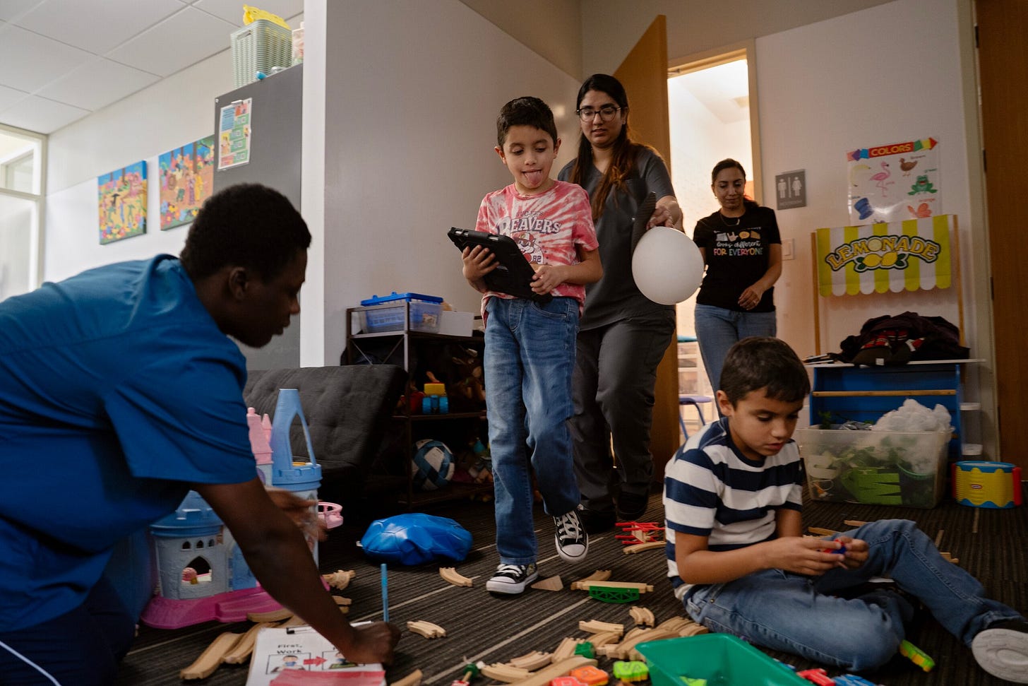 Israel Solis, 7, center left, walks to his work area while his brother, Eleazar Solis, 9, far right, plays with blocks during their ABA therapy class at the University of Houston-Clear Lake on Oct. 8, 2026.