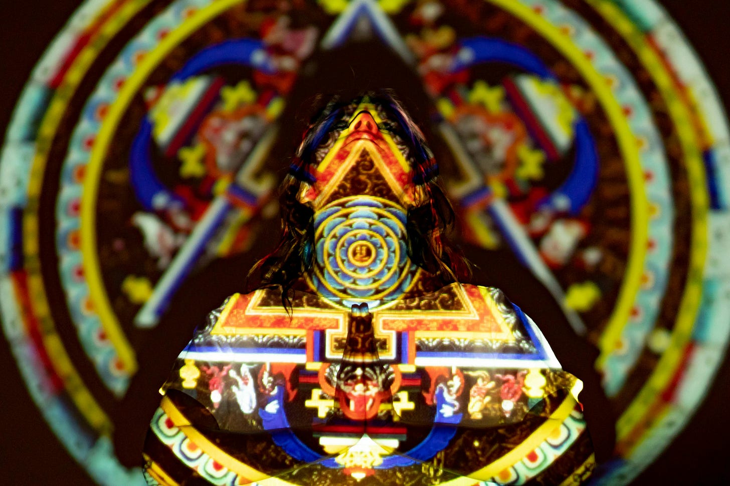 A human face overlaid with glowing mandala patterns, blending spiritual iconography with digital projection — symbolizing samsara in the algorithmic age.
