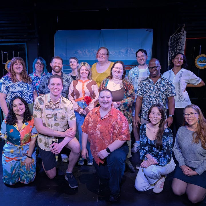 In left photo, a man in a MAGIC THE GATHERING T-shirt and blues jeans holds up another man as several of The Rose improv trouple members look on with a mixture of admiration and surprise. The men being hold is triumphantly holding up a rose.