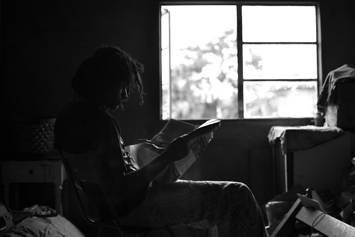 woman reads the paper by the window