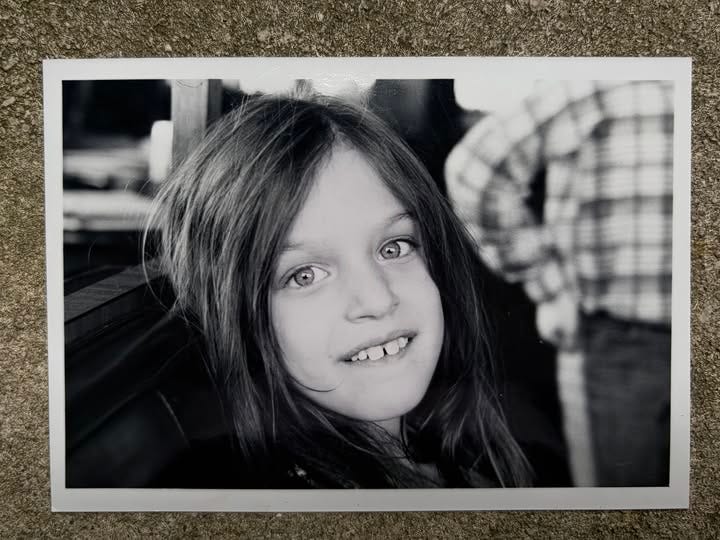 May be a black-and-white image of child, smiling and polaroid